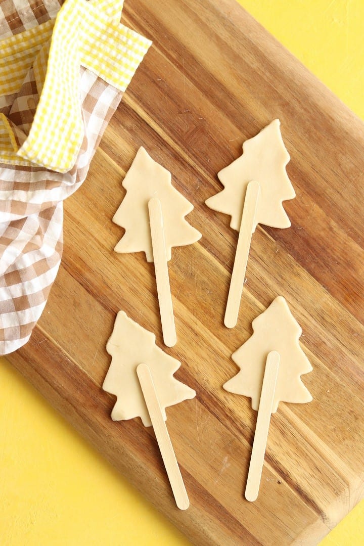 pie dough shaped in christmas trees with craft sticks