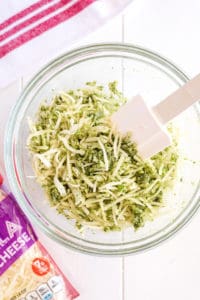 Bowl of grated broccoli, pesto and cheeses