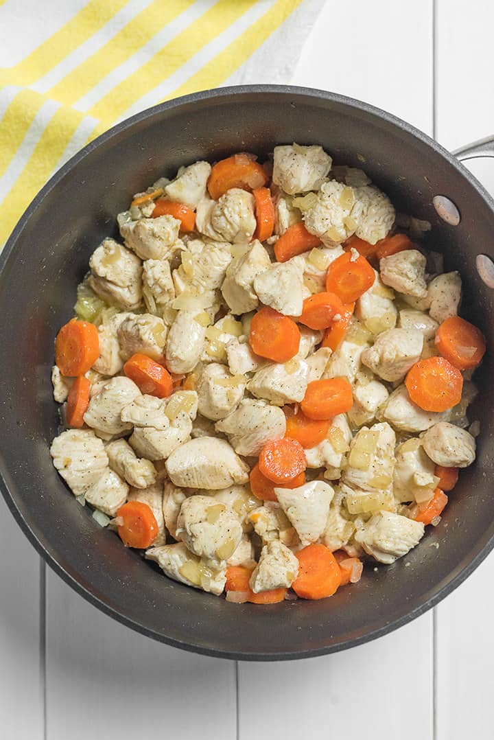 Dutch oven filled with chicken carrots and onions 