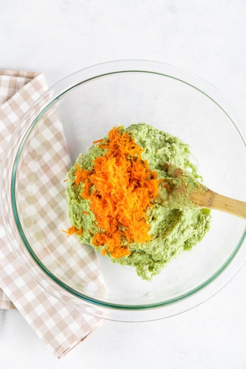 bowl of green mixture and grated carrots