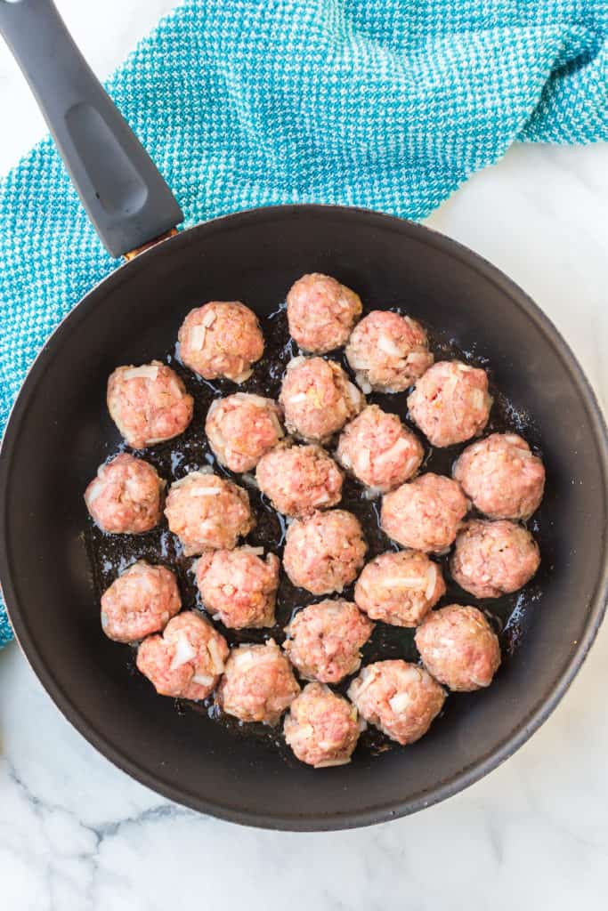 Pan with raw meatballs cooking in olive oil 