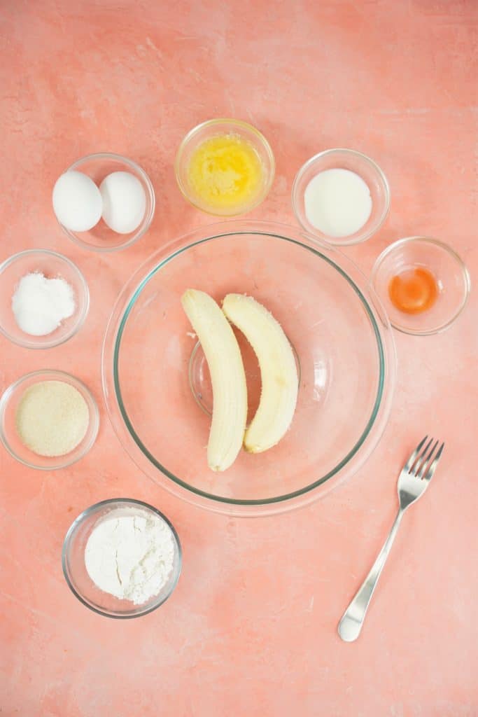 bowls of ingredients on a pink background with a fork