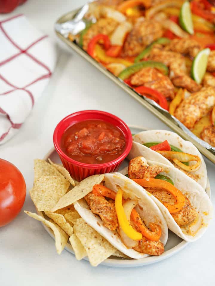 Plate of cooked chicken fajitas with sheet pan in view