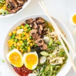 Three bowls filled with ramen and vegetbales with hard boiled egg and vegetables and sambal