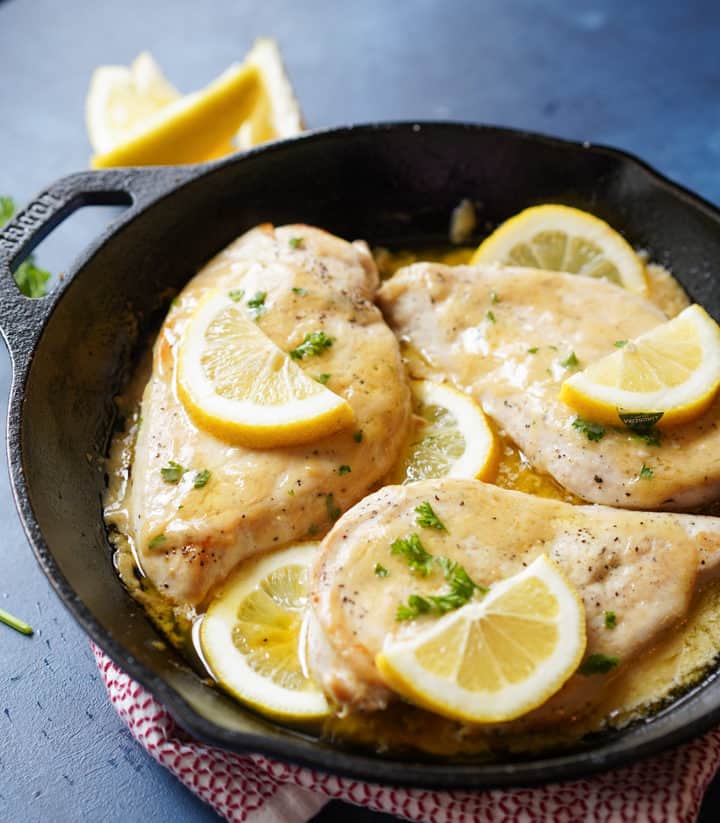 Close up of baked lemon chicken with lemons on top