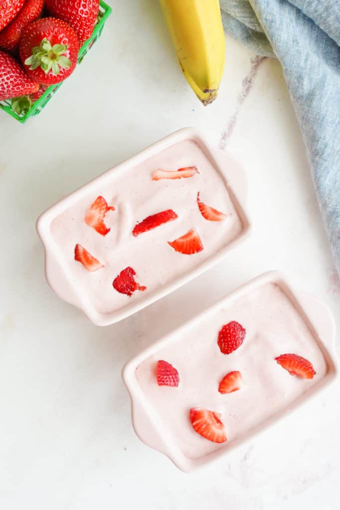 two glass pink containers filled with ice cream