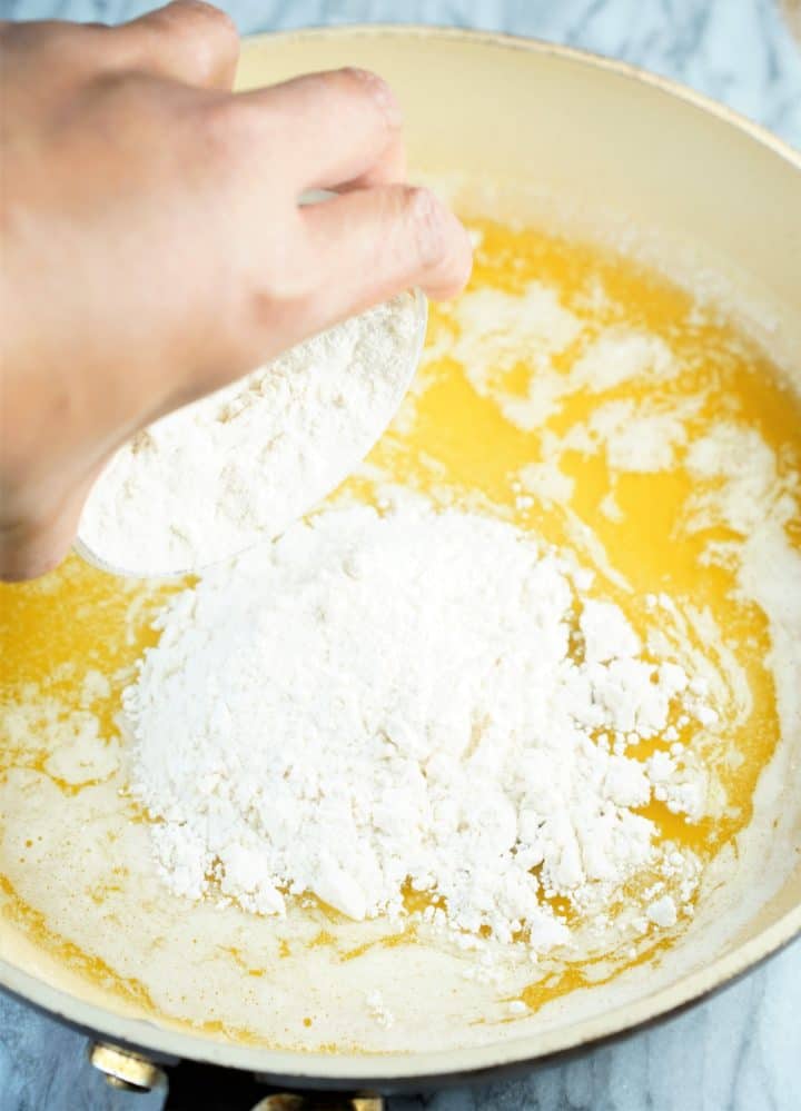 Pan of melted butter with flour being poured