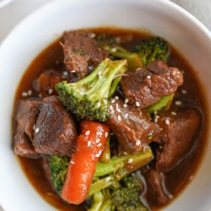 korean beef in a bowl with broccoli carrots and sesame seeds