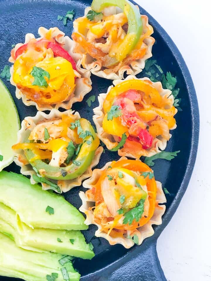 Close up of chicken fajita cups in a cast iron skillet
