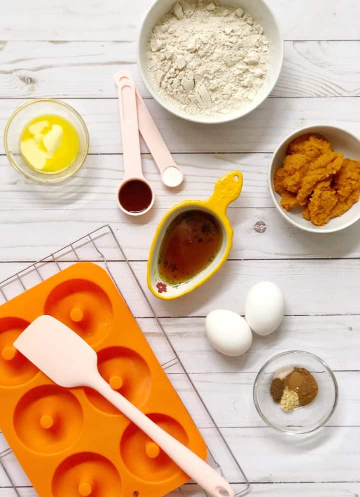 flat lay of ingredients like pumpkin puree, flour eggs and spices