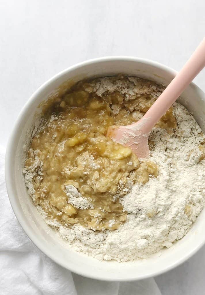 Bowl of creamed sugar, mashed bananas and flour next to applesauce 