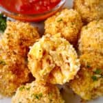 close up of mac and cheese balls with marinara on the side