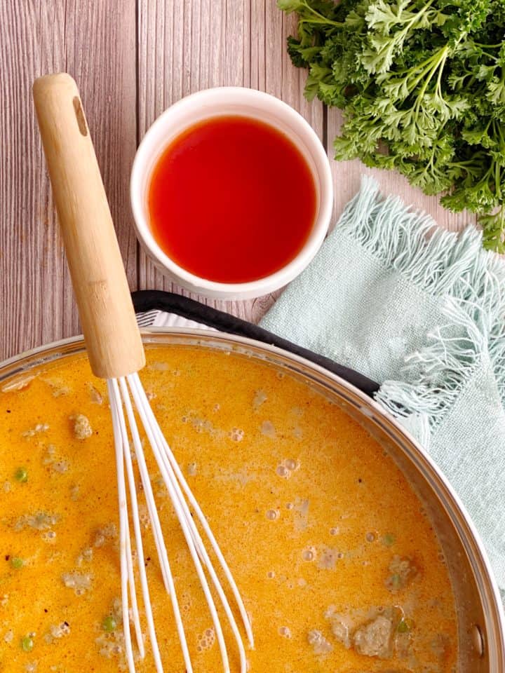 pan of cheesy sauce next to bowl of tomato sauce 