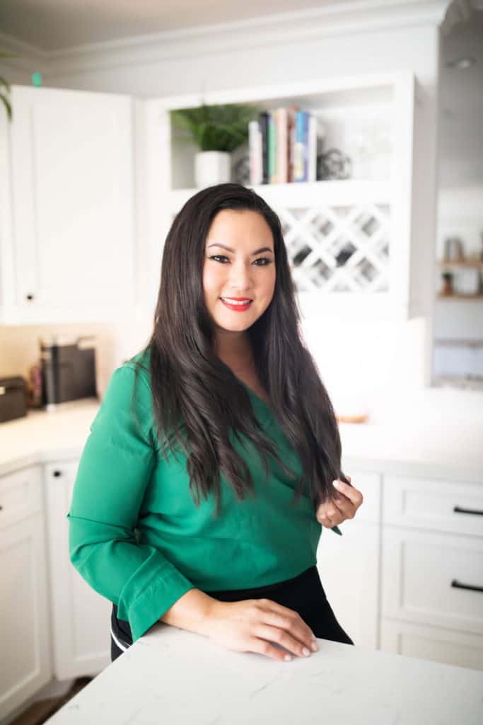 woman in green shirt in a white kitchen 