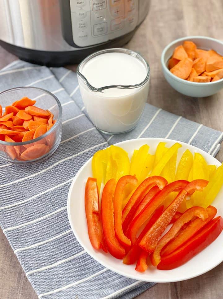 array of ingredients including bell pepper, coconut milk, and carrots 
