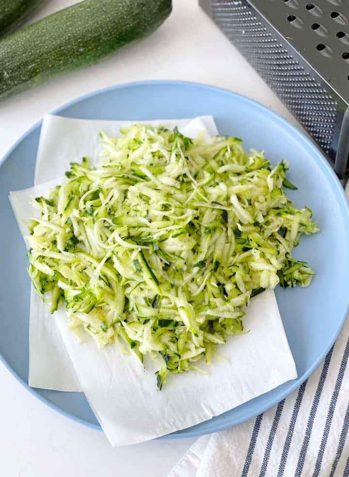 grated zucchini on paper towel on plate