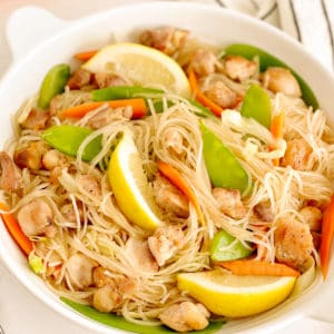 close up of pancit bihon in a bowl on top of a napkin