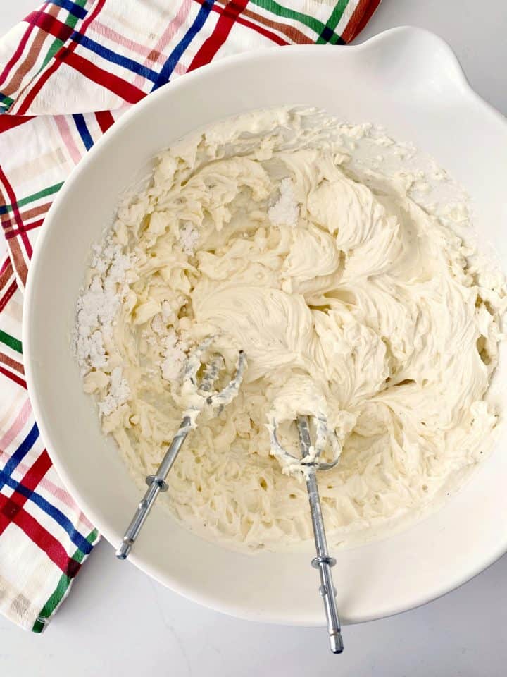 whipped cheese in a bowl with whisk 