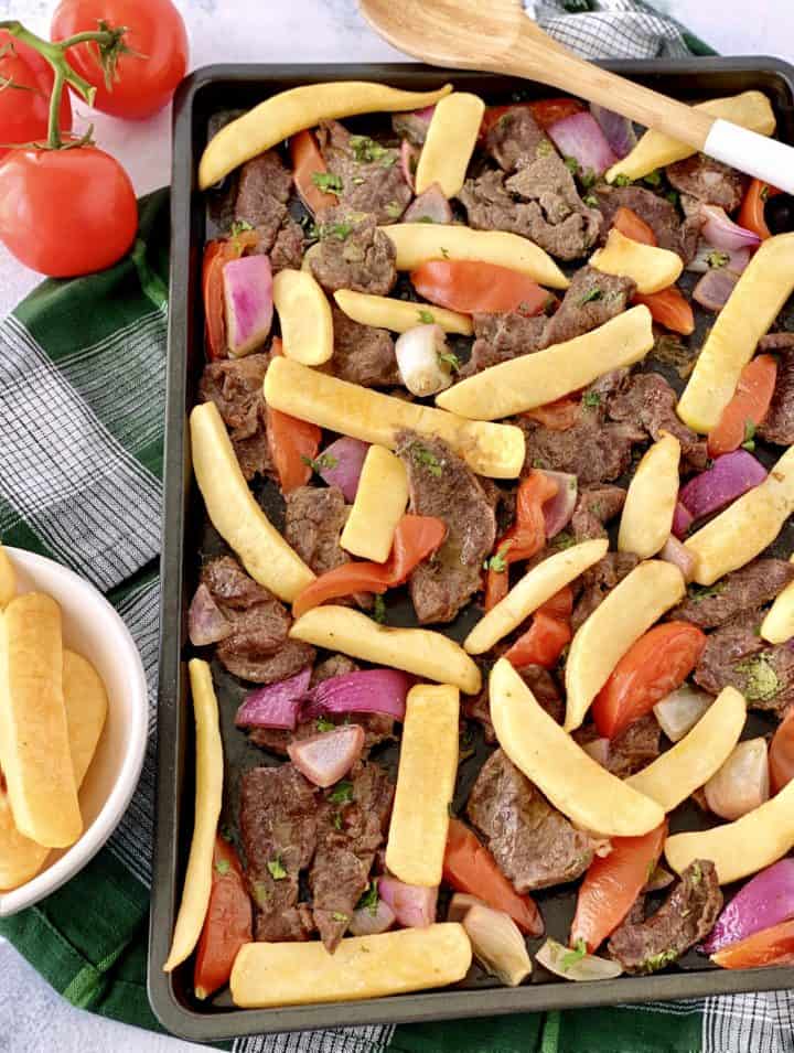 cooked lomo saltado with all ingredients on a sheet pan