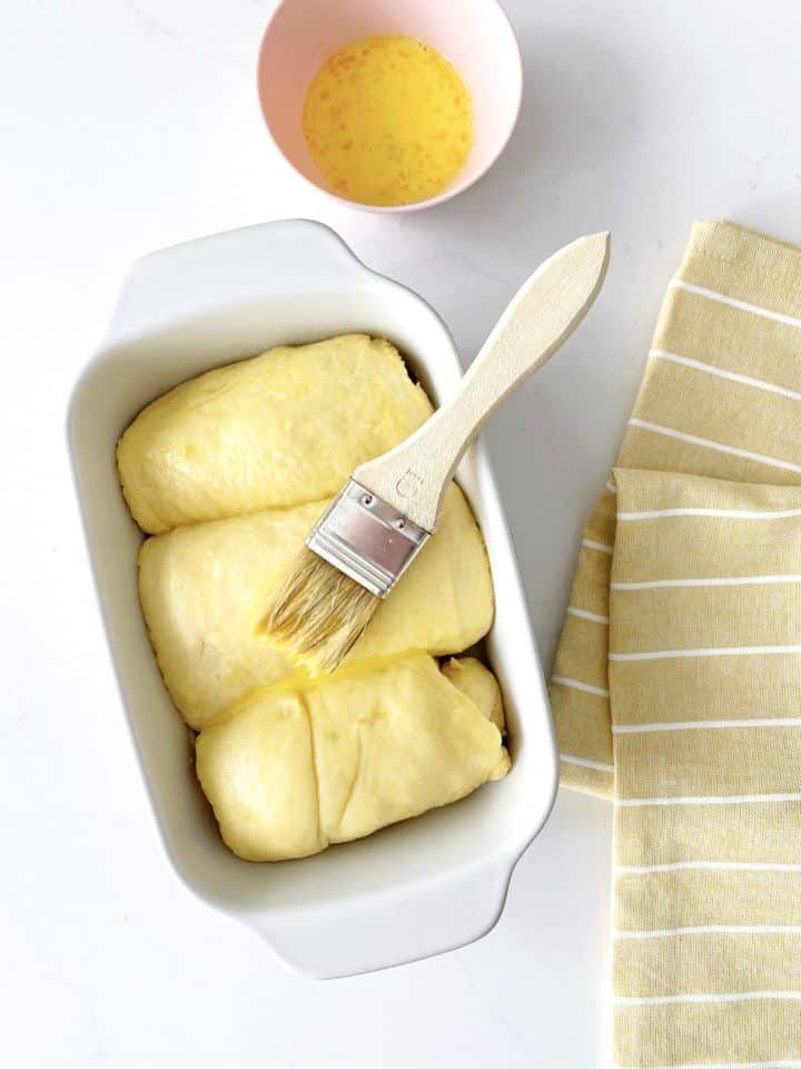pastry brush on dough in a pan 
