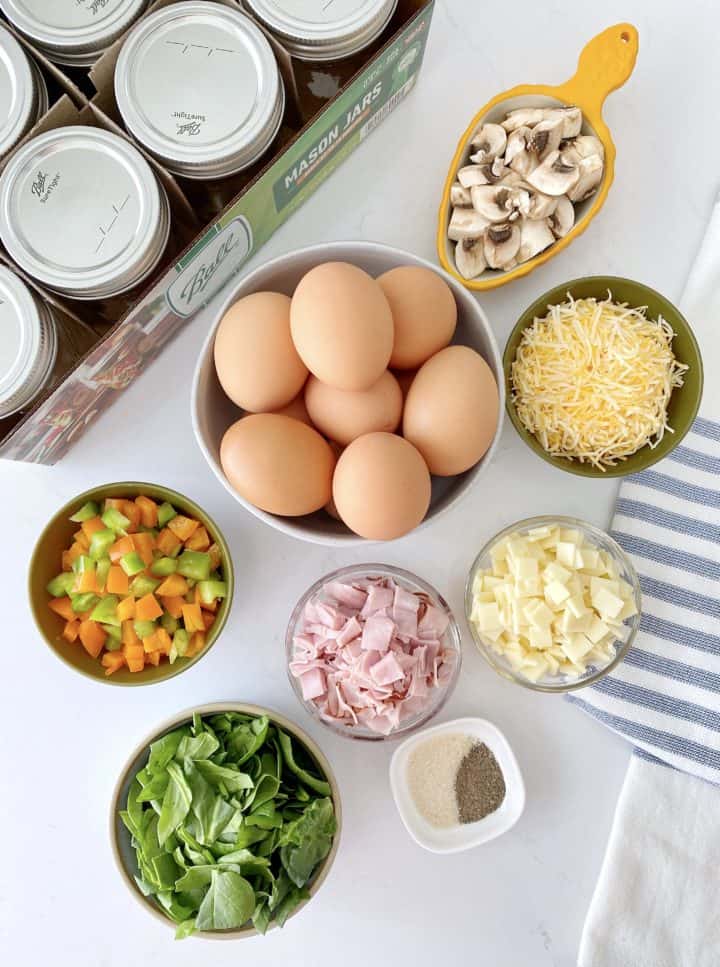 bowl of eggs, mixed veggies, mushroom, ham, cheese, spinach and clean mason jars to make microwave scrambled eggs