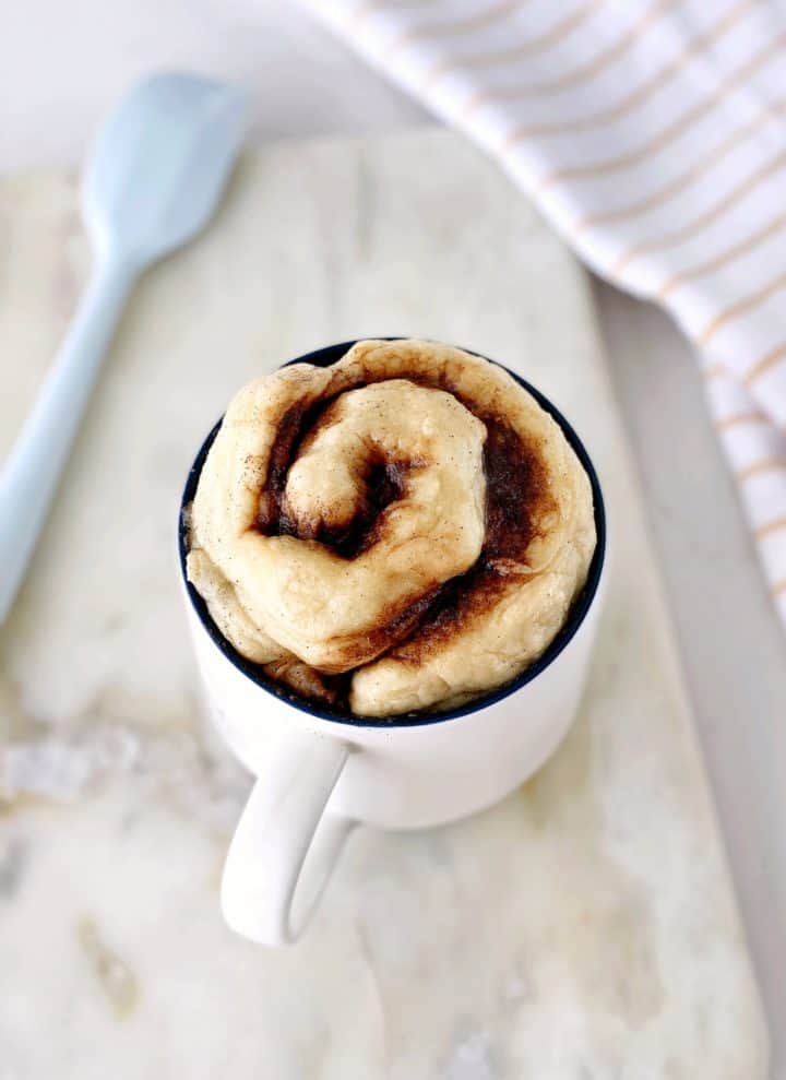 cinnamon roll in mug with spoon 