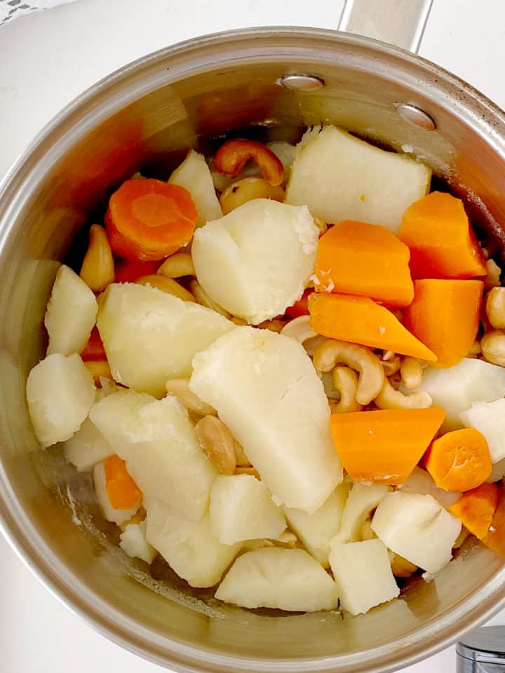 close up of carrots, cashews, and carrots in a pot 