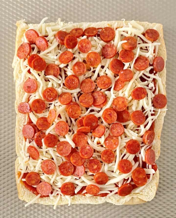 close up of roll with pizza sauce, pepperoni and cheese 