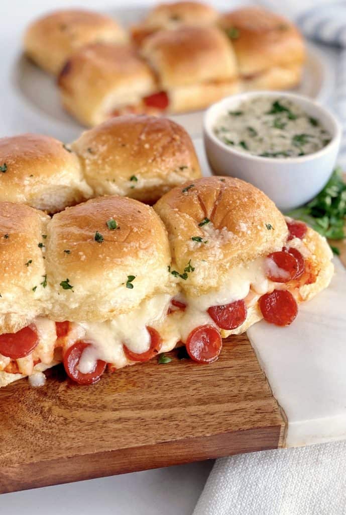 rolls on a wooden board with pepperoni and cheese 