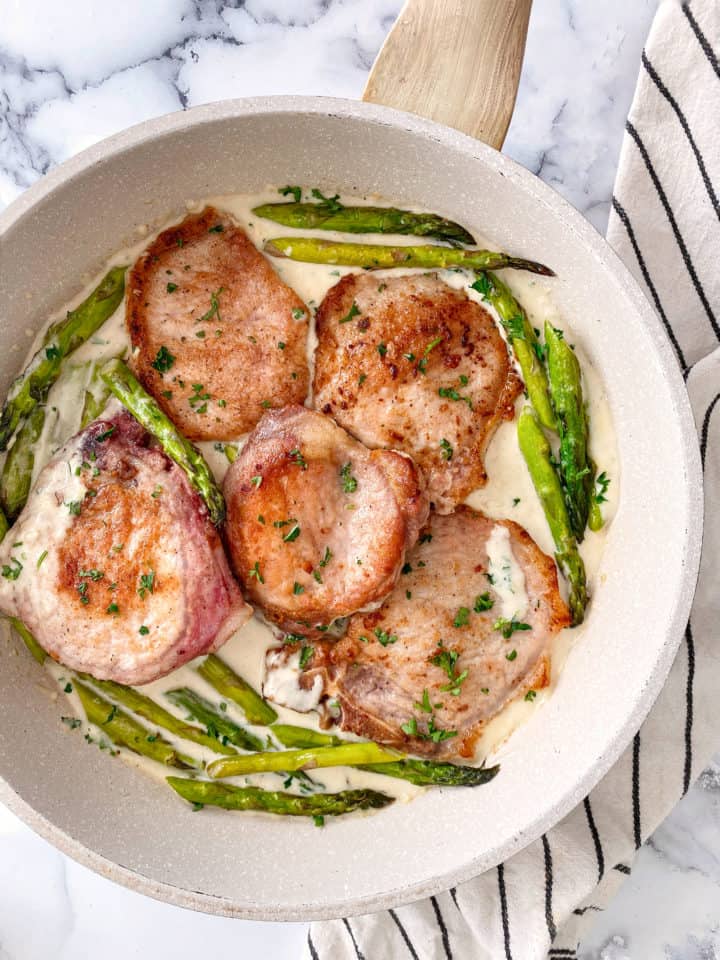 pan with pork chops and cream sauce and asparagus 
