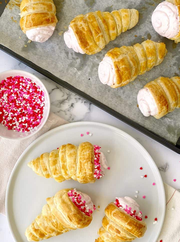 cream horns on baking sheet and some on serving plate 