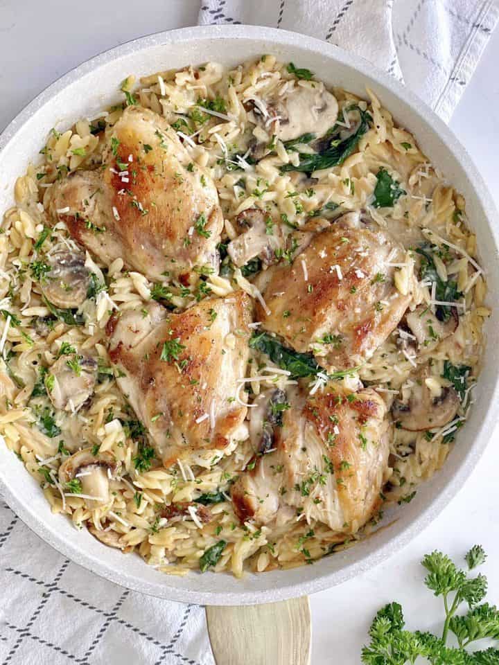 pan with orzo and chicken and spinach in a pan 