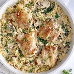 pan with orzo and spinach and chicken thighs in a pan