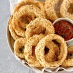 bowl of onion rings next to ketchup
