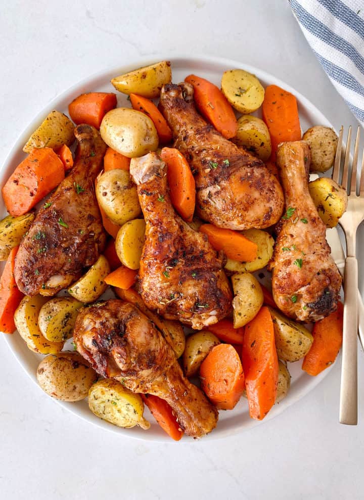 plate of air fryer chicken legs with potato and carrots