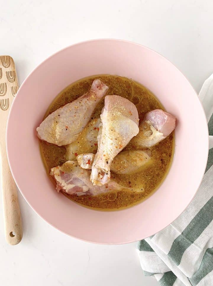 bowl of marinade with chicken legs