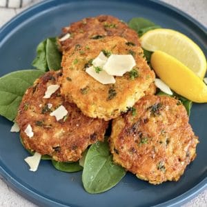 chicken patties on a blue plate with slice of lemon