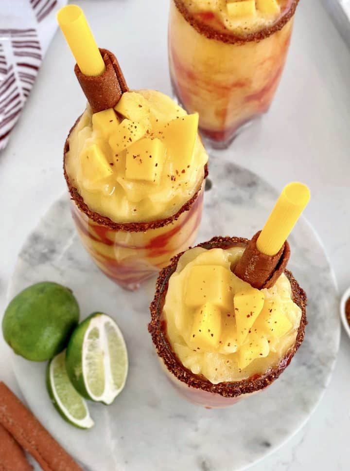 two mangonadas on a tray one on the side with limes