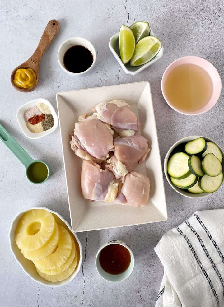 chicken, zucchini and seasonings on a flat lay 