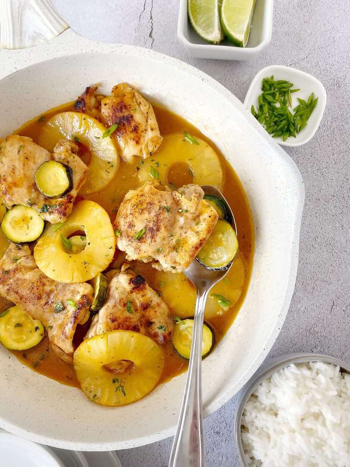 bowl of chicken with sauce next to rice bowl