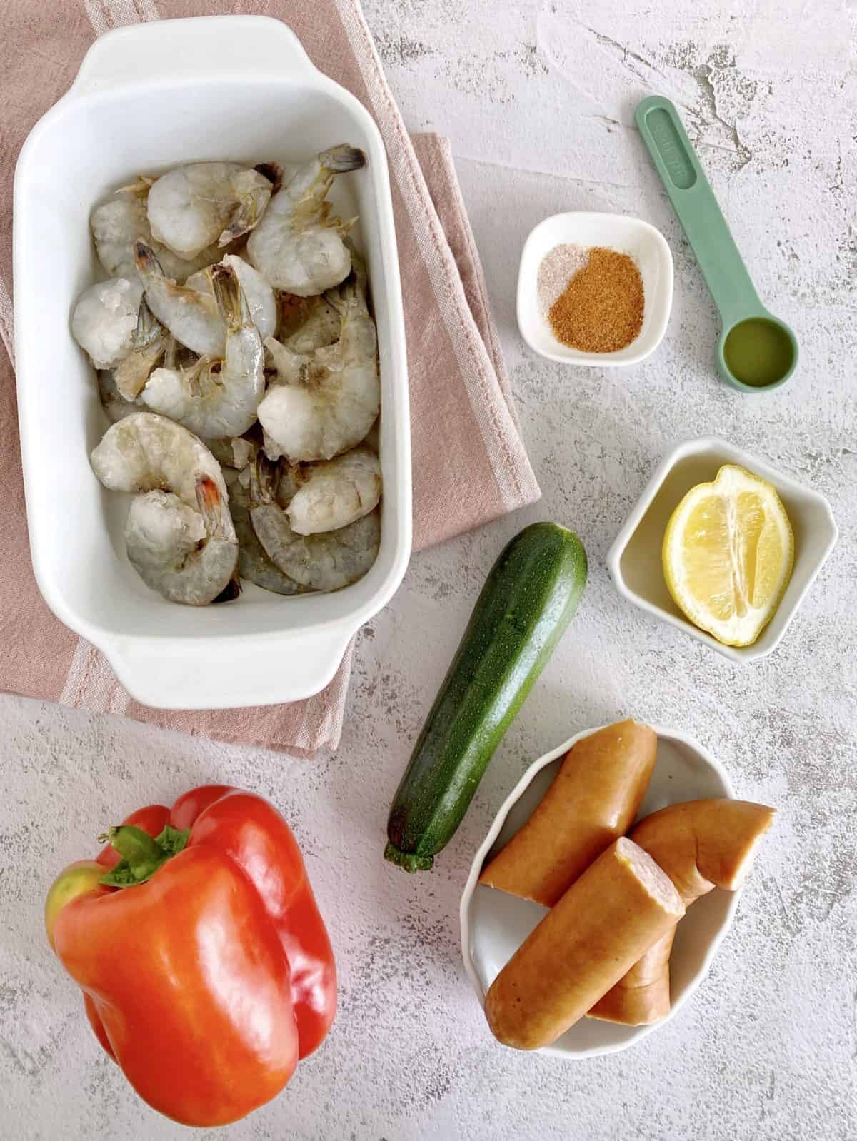 flat lay of ingredients including shrimp, bell pepper, zucchini and spices