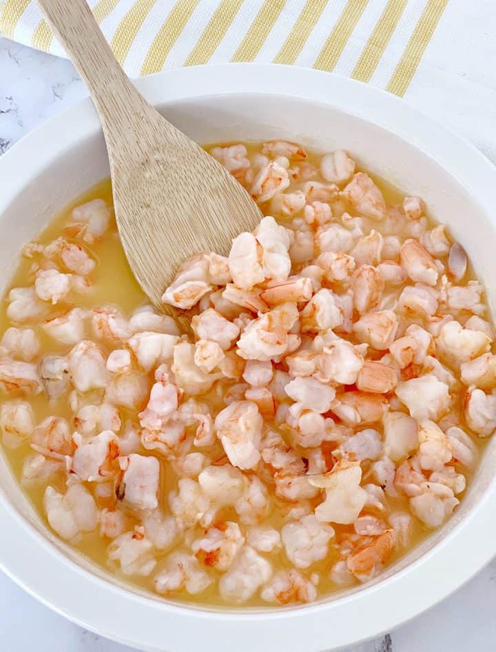 cured shrimp in juices with a spoon 