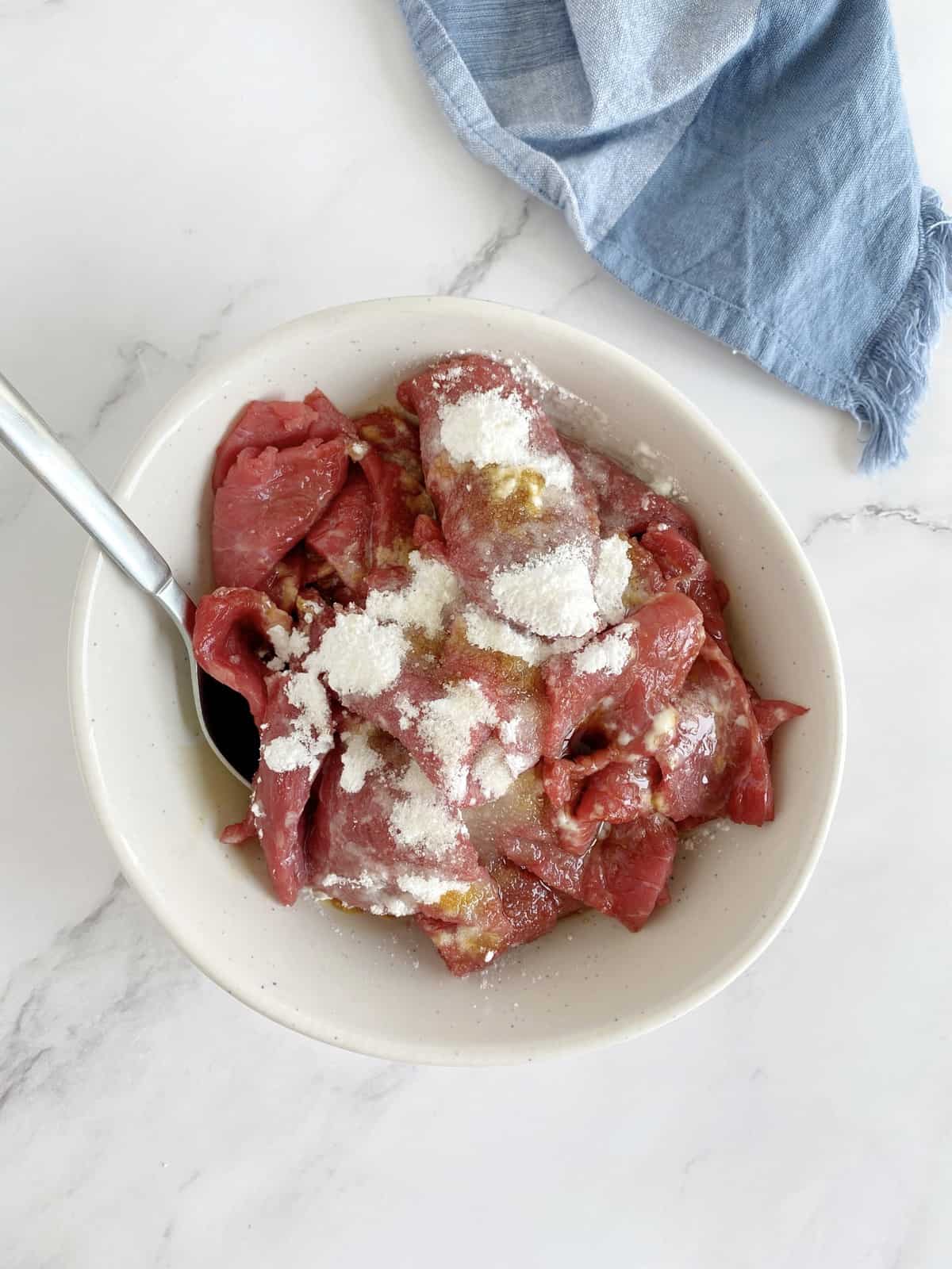 bowl of cornstarch and seasonings with beef