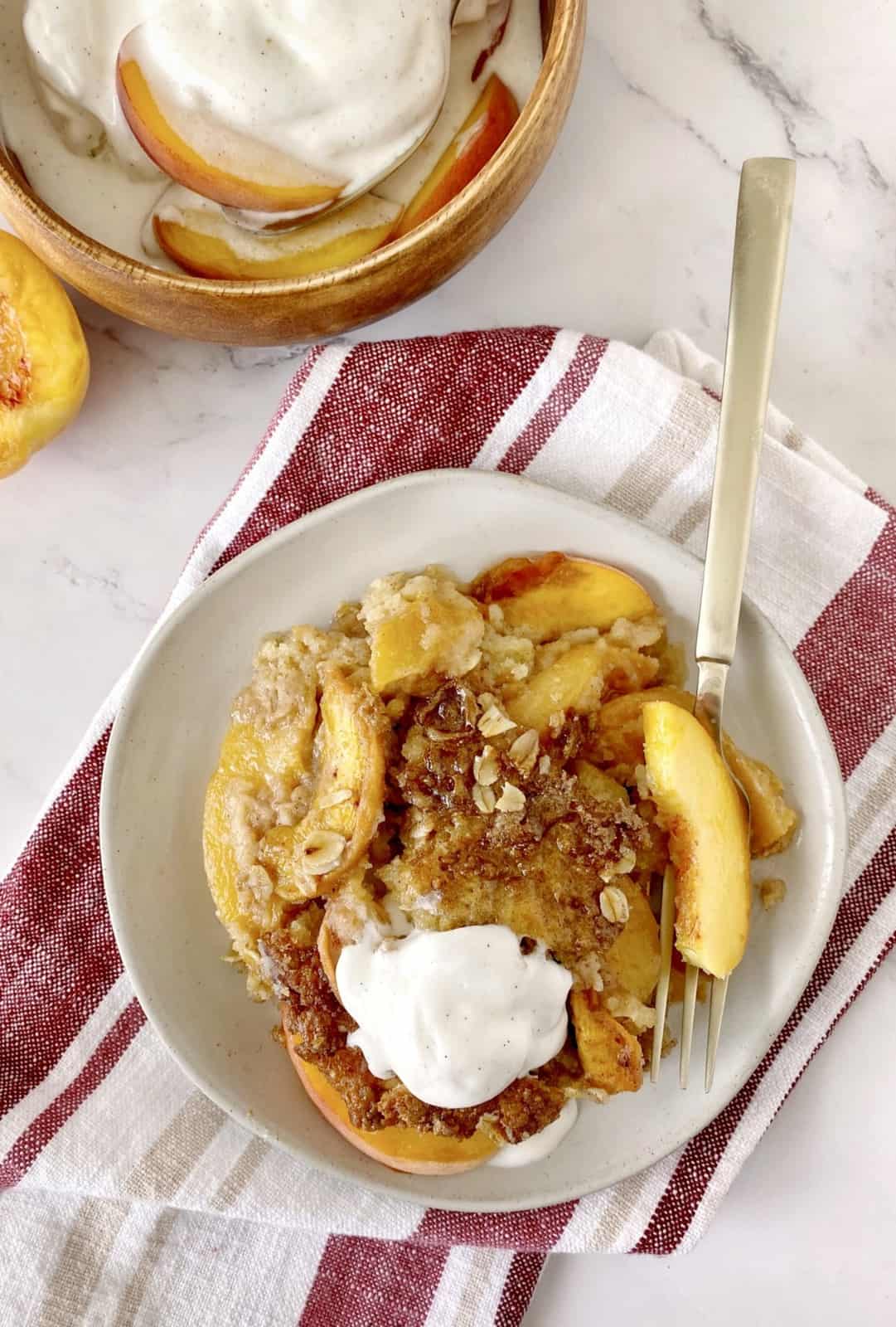 dish of peach cobbler with ice cream on top