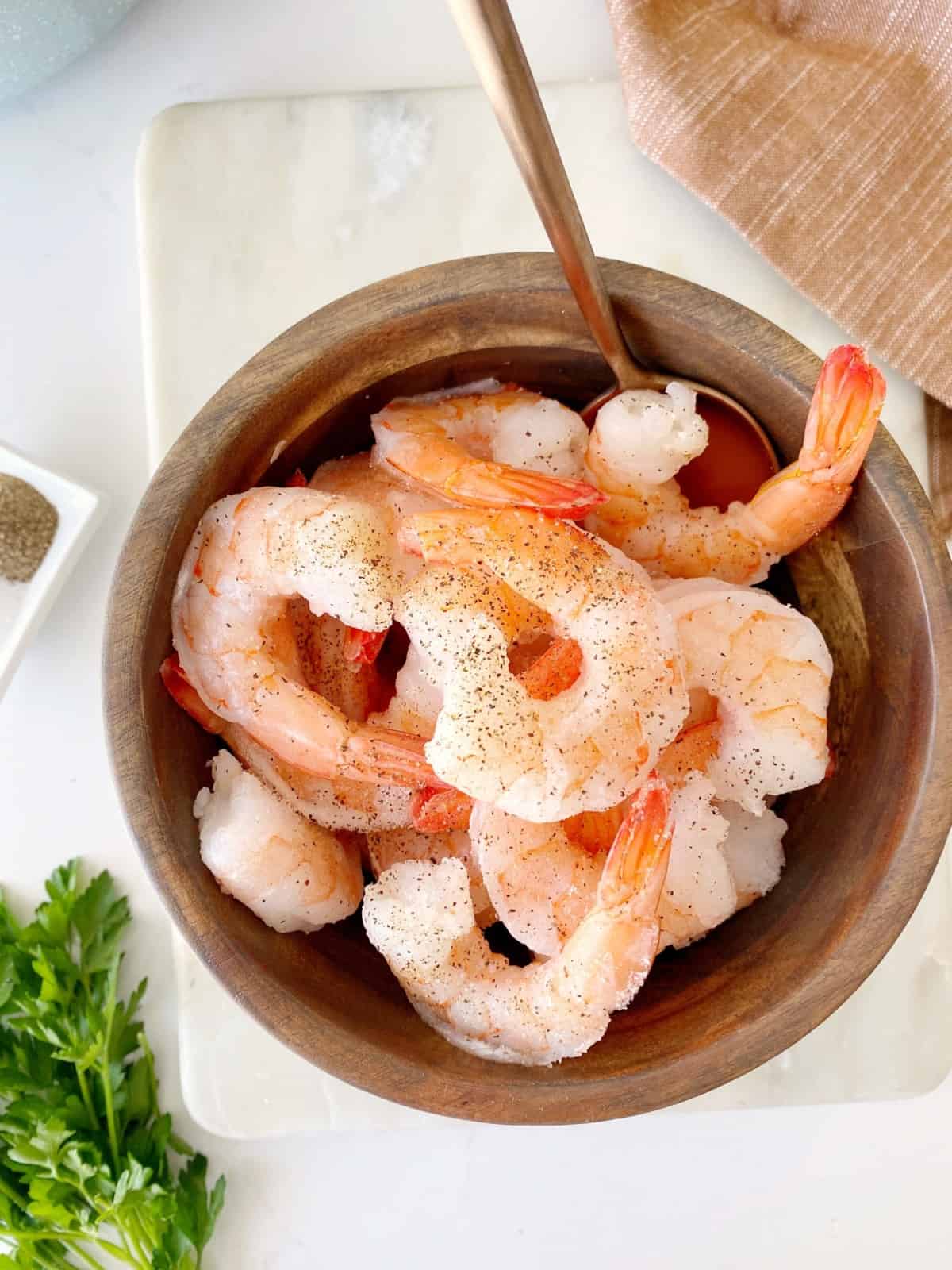 deveined shrimp in a bowl with salt and pepper