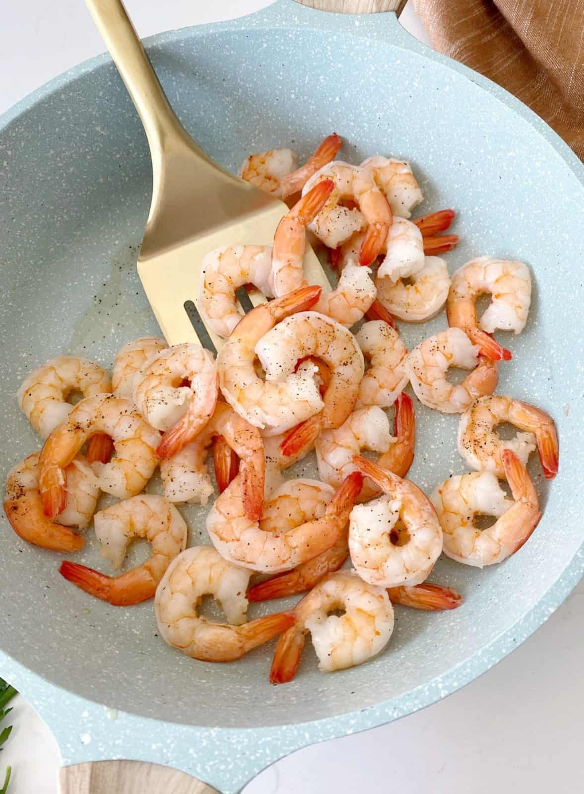 shrimp in  pan with spatula 
