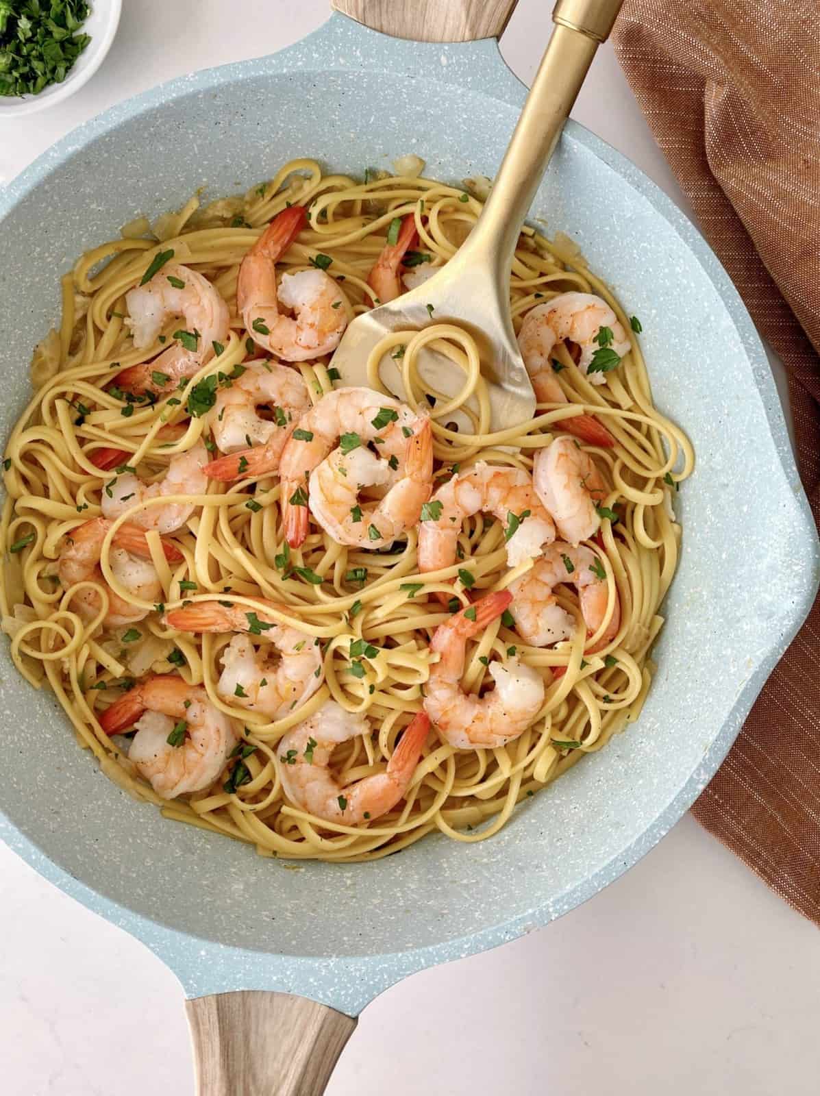 scampi shrimp in pan with noodles and garnish