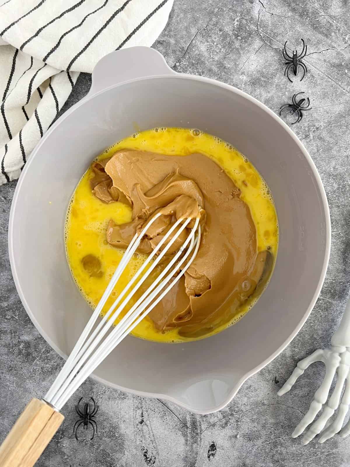 bowl of eggs and peanut butter with whisk 