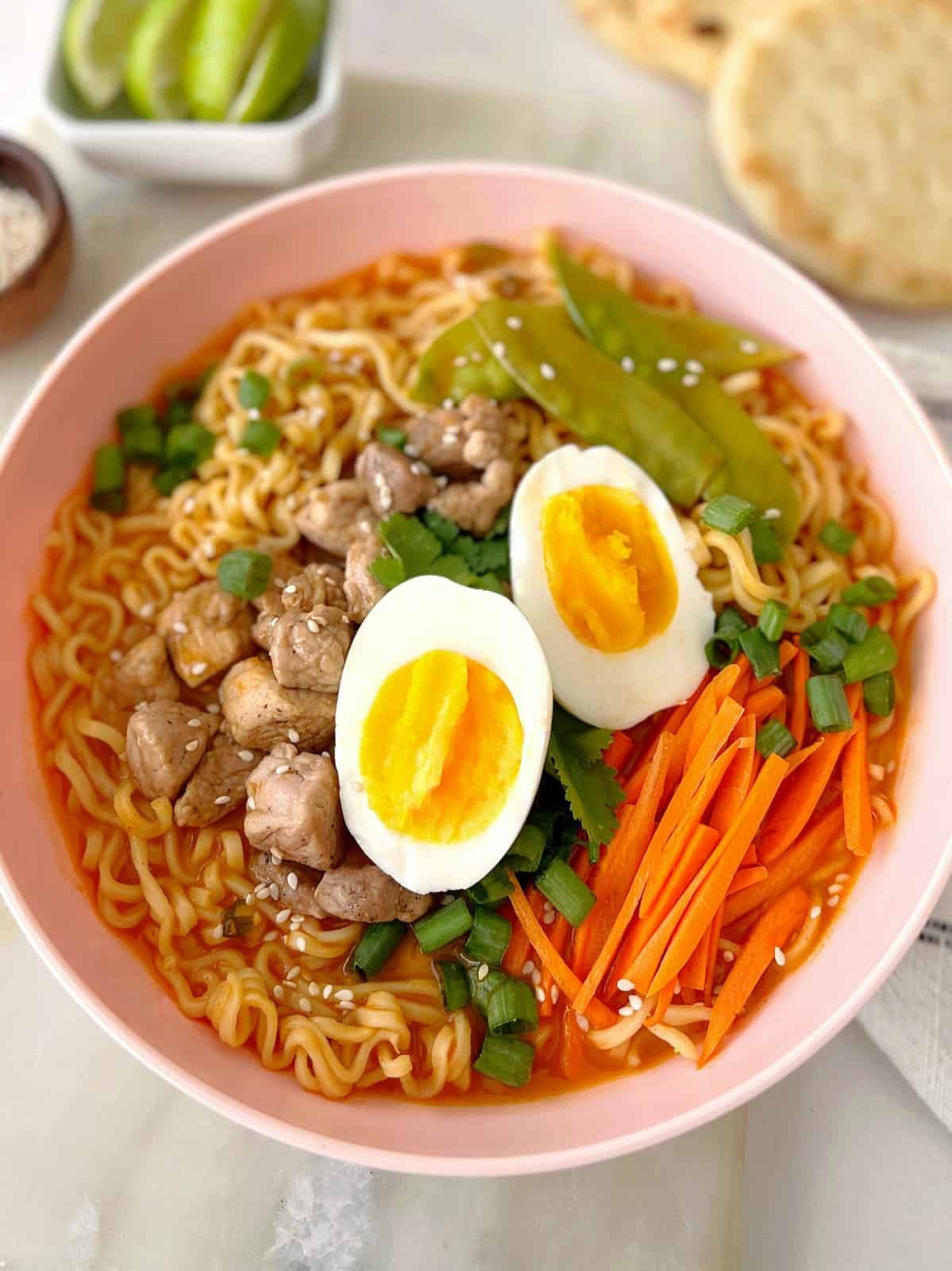 bowl of ramen with eggs carrots and garnish