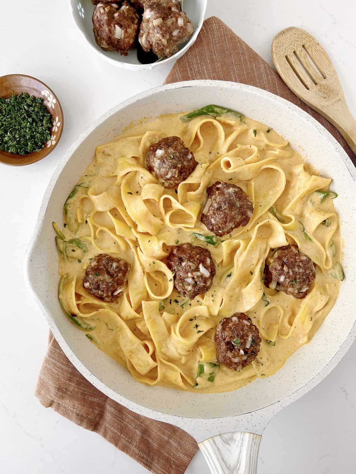 plate of pumpkin pasta with meatballs on a wooden tray 